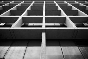 Symetryczna fasada nowoczesnego budynku z rytmicznymi pionowymi podziałami, sfotografowana przez fotograf architektury. Christchurch NZ